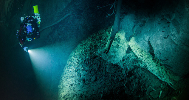 In this underwater photo taken Aug. 15, 2015 in the flooded Hranicka Propast, or Hranice Abyss, in the Czech Republic is seen Polish explorer Krzysztof Starnawski exploring the limestone abyss and preparing for deeper exploration with the use of a remotely-operated underwater robot, or ROV. On Sept. 27, 2016, the robot went to the record depth of 404 meters (1,325 feet) revealing the abyss to be the world's deepest flooded cave, during the 'Hranicka Propast - step beyond 400m' expedition led by Starnawski and partly funded by the National Geographic. (Krzysztof Starnawski of EXPEDITION via AP)