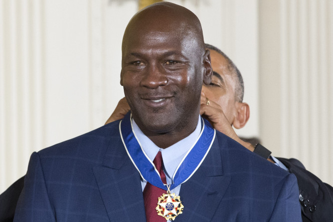 epa05643049 US President Barack Obama (Back) awards the Presidential Medal of Freedom to retired basketball player Michael Jordan (Front) during a ceremony in the East Room of the White House in Washington, DC, USA, 22 November 2016. EPA/MICHAEL REYNOLDS