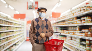 Senior man shopping in a supermarket with a medical face mask